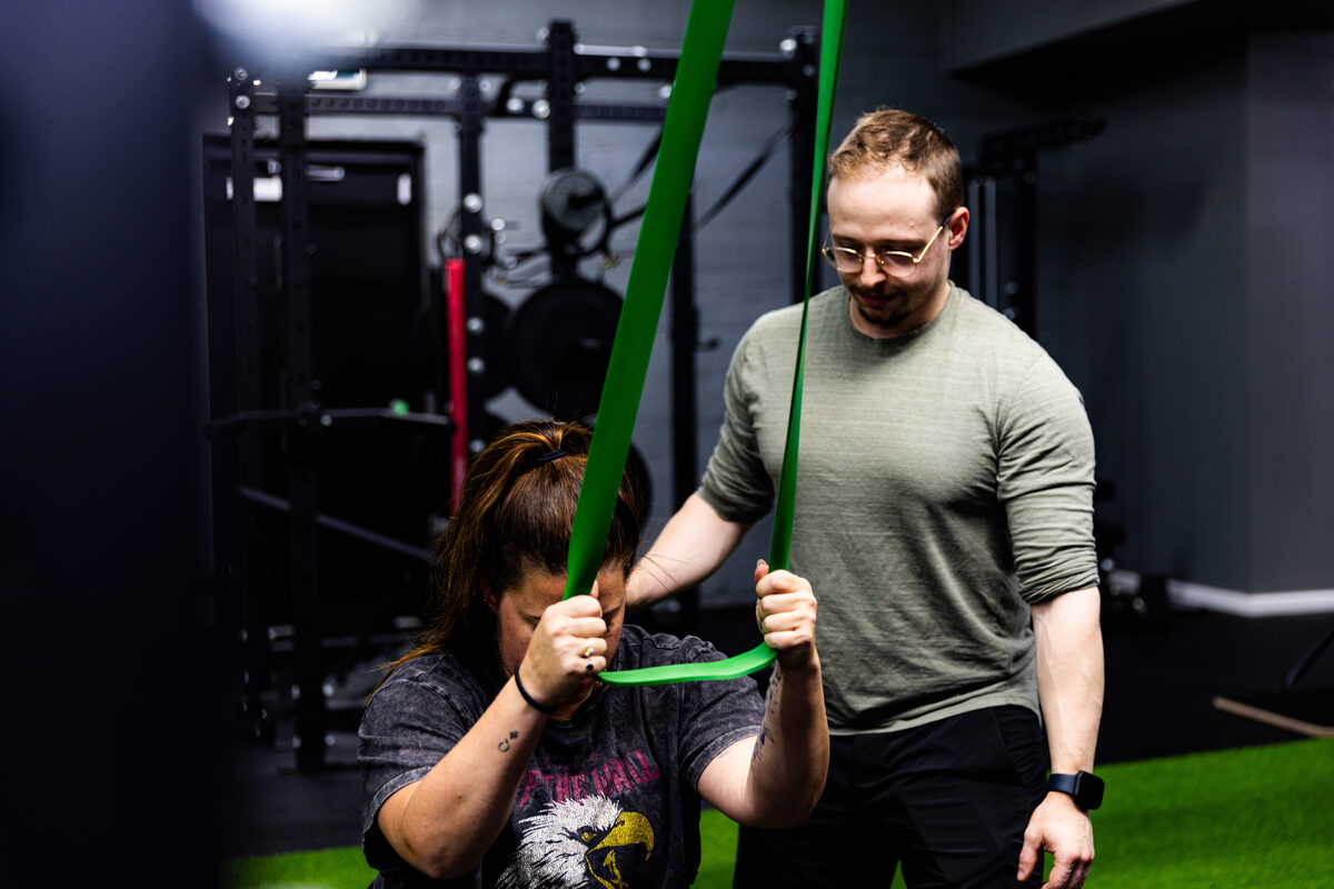 An eFIT coach supporting a member through resistance-band mobility work